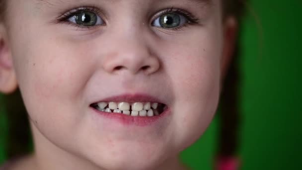 这个女孩露出她的婴儿牙齿，白色的婴儿牙齿，口腔卫生，动作缓慢. — 图库视频影像