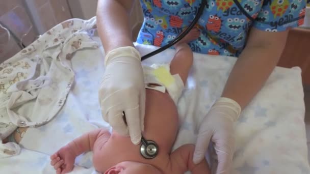Педиатр слушает новорожденного со стетоскопом. — стоковое видео