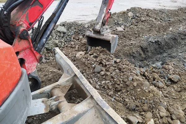 Sebuah ekskavator menggali parit untuk limbah dan air hujan di sepanjang sisi jalan. — Stok Foto