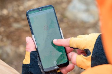 Adam dağlarda akıllı telefon kullanarak yolu kapatıyor, dağlarda navigatör, dağlarda navigatör olarak akıllı telefon kullanıyor..