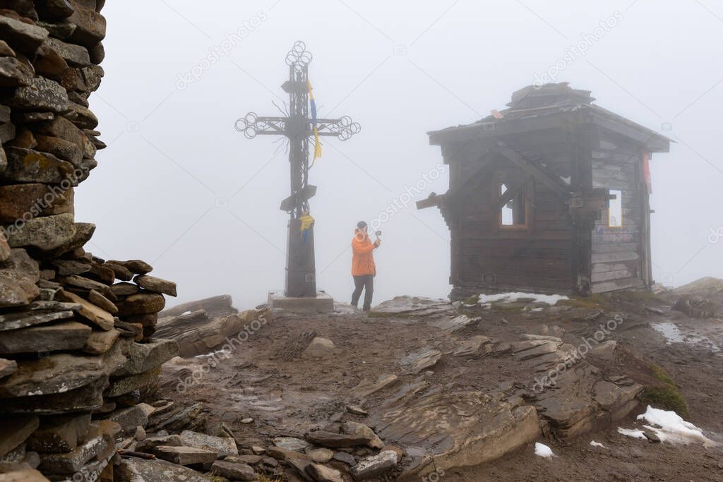 The top of Mount Petros, the Christian cross and the inactive chapel on top of the mountain, the top of the mountain in fog and snow.