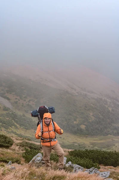 Een Man Beklimt Een Berg Mist Een Man Draagt Een — Stockfoto