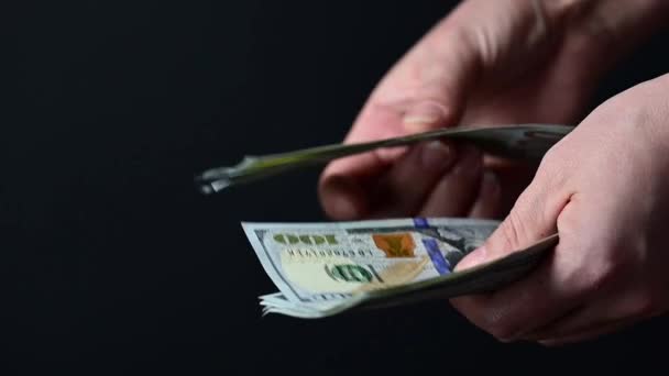 Yüz dolarlık banknotlar sayıyor, iş adamları para sayıyor, para siyah bir arkaplanda.. — Stok video