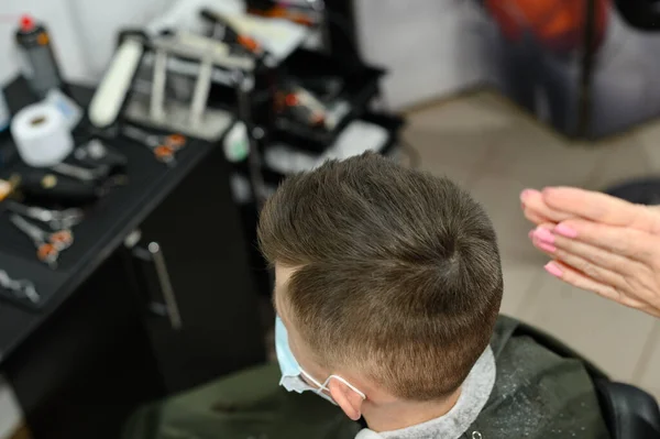理发师在理发后给男孩子理发 在理发后给男孩子理发 在理发后用发胶和梳子理发 — 图库照片
