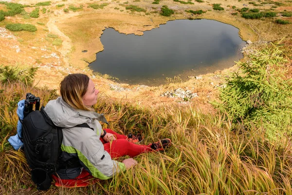 Toerist Zit Het Gras Hoog Bergen Achtergrond Van Lake Nesamovite — Stockfoto