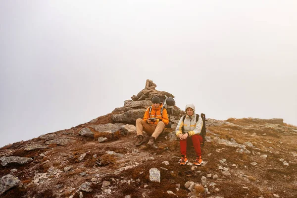 観光客は ウクライナのカルパティアを歩くと 観光客は背中に重いバックパックを運ぶ 2人の観光客はスピッツ山の上に座る — ストック写真