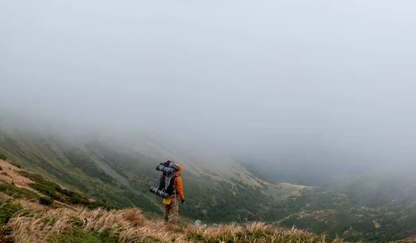 絵のように美しいカルパティア人 絵のような秋のカルパティア人 雲の中のカルパティア山脈の頂上を背景にしたバックパックを持つ観光客 — ストック写真