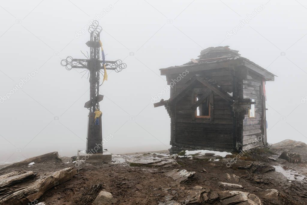 The top of Mount Petros, the Christian cross and the inactive chapel on top of the mountain, the top of the mountain in fog and snow.