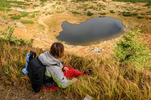 Toerist Zit Het Gras Hoog Bergen Achtergrond Van Lake Nesamovite — Stockfoto