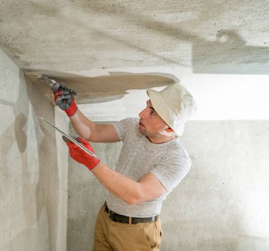 Duvarları yıkmak için kireç alçı, usta odada tamirat yapar, duvarları beton harçla yıkar..