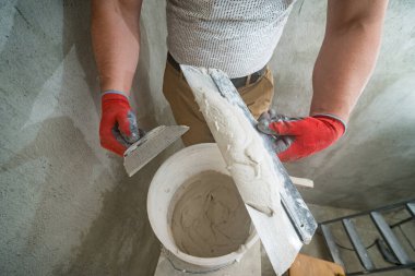 Bir spatula üzerine limon sıva, kireç sıva ile onarım ve dekorasyon işi, iki kirli spatula, kovada kireç sıva..