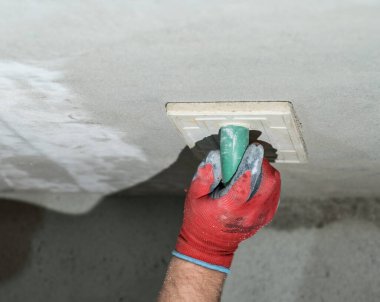 Duvarı yıkmak için nemlendirici süngerle taze kireç sıva sürüyorum. İnşaat rendesi kapanıyor..