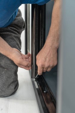 Sürgülü bir gardıroba açılan aynalı kapılar montajı, altıgen vida vasıtasıyla bir kasa montajı, ayrıntılı bir plan üzerinde çalışmak.