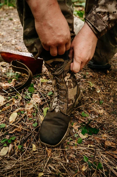 A soldier ties shoelaces, military shoes and the army.