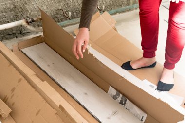 Kadın kutudan bir kuvars plağı çıkarır, zemini onarmak için tamir eder..