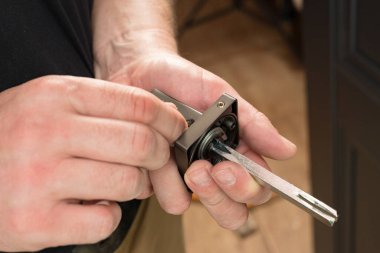Handyman holding a doorknob and hex key, doorknob installation, metal doorknob.