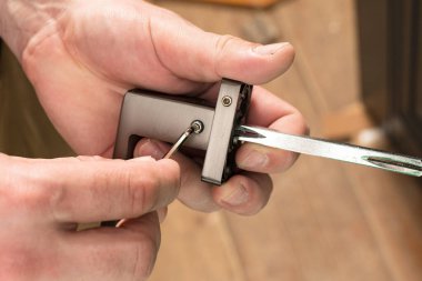 Handyman holding a doorknob and hex key, doorknob installation, metal doorknob.
