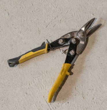 Metal ve metal yapı elementlerini kesmek için makas yerde yatıyor..