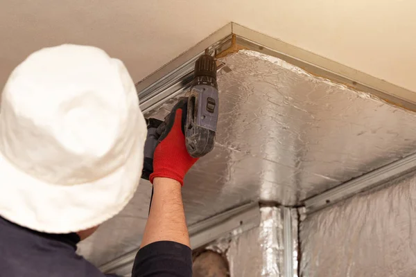 Mineral wool with foil, thermal protection for the wall from the fireplace, installation of metal beacons, screwing the beacons to the wall with a screwdriver, Construction works.