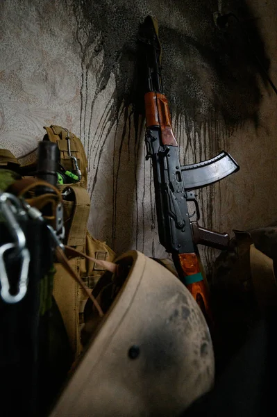 The Ukrainian soldier\'s machine gun is leaning against the wall in the house, the war in Ukraine, weapons and armor in an abandoned house.