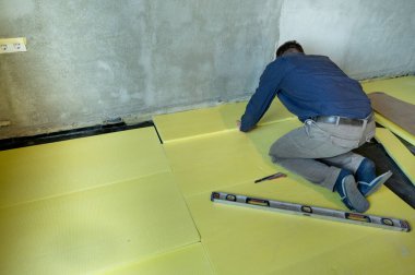 Genişletilmiş polistiren döşeme izolasyonu, tek başına onarım çalışmaları, sarı genişletilmiş polistiren, içerideki evin yalıtımı.