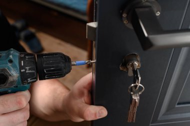 Installation of a lock and door handle to an interior door, a locksmith works with the door, the keys are in the door lock.