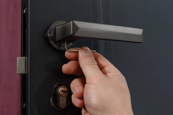 Hex key and installation of door lock and handle, close-up installation work, interior door.