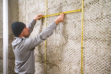 Kılavuz metal şamandıralar arasındaki mesafeyi ölçmek, ahşap bir duvara bağlı metal şamandıralar, evdeki tamir işleri.