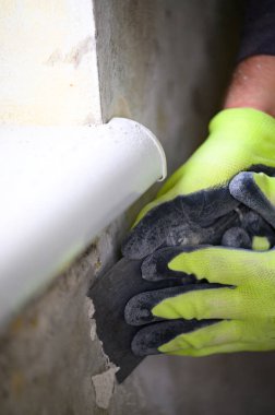 Mantar ve küf, odadaki aşırı nemi gösterir. Elinde spatula olan bir adam, duvardan mantar ve küf çıkarır. Zararlı küf ve mantar..