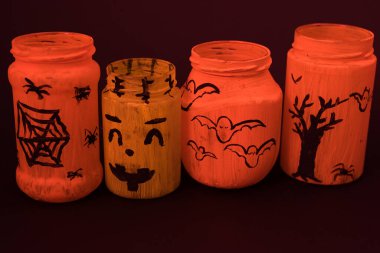 Painted jar decoration for Halloween, children's crafts for the Halloween holiday, isolated jars on a black background.