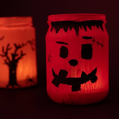 Hand painted Halloween jar, orange jar on black background, handmade and Halloween decoration.