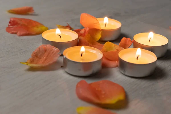 Rose petals and scented candle set, romantic evening, five candles and flower petals.