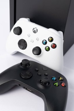 Ivano-Frankivsk, Ukraine August 14, 2022: gamepad and console on a white background, black and white gamepads, game console from Microsoft.