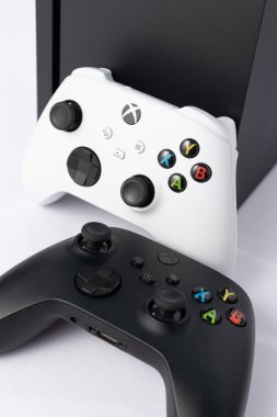 Ivano-Frankivsk, Ukraine August 14, 2022: gamepad and console on a white background, black and white gamepads, game console from Microsoft. clipart