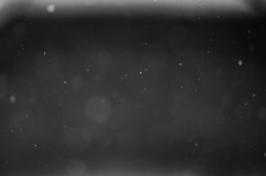 Siyah arkaplandaki Bokeh beyaz kar. Kar yağışı - yeni tasarım ögesi.