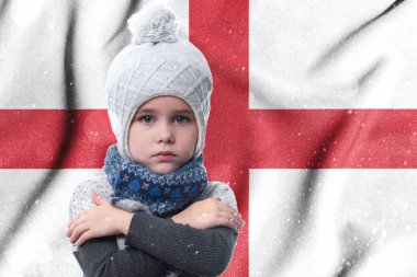 Cold winter and the consequences of gas sanctions, the consequences of the war in Ukraine, the shortage of gas and heat in England, the girl is frozen, the child without heat in winter hugs himself with his arms to keep warm.