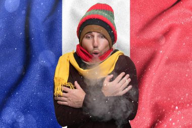 France suffers the consequences of a cold and unheated winter, a European freezes from the cold and warms himself with steam from his mouth.
