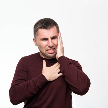 A man suffers from a toothache, portrait on a white background, painful facial expression due to toothache or dental disease.