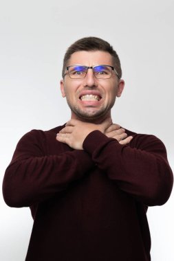 Handsome man in glasses over isolated background touching painful neck, sore throat from flu, cold and infection, man with light beard.