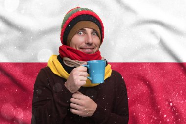 Gas crisis in Poland, Cold winter and high gas tariffs, a smiling man warms himself with a cup of tea and warm clothes.
