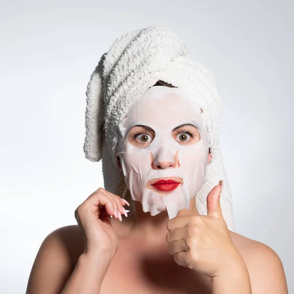 Portrait of a woman with a cotton mask to moisturize her face, place for advertising and inscription.