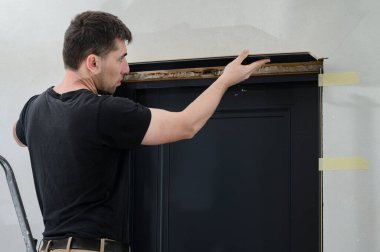 Metal bir kural ile kurulduktan sonra yüzey eşitliği için kapı çerçevesini kontrol etmek, kapı ayarları kurulumu.