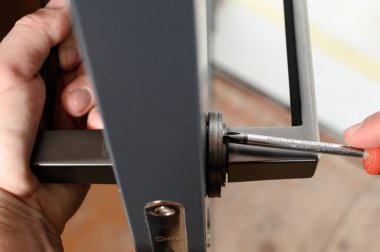 Ivano-Frankivsk, Ukraine May 16, 2022: installation of the door lock, screwing the handle to the lock.