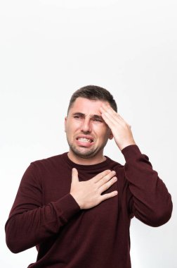 Emotions of a man from a headache, a man suffers from a severe migraine, portrait on a white background isolated.