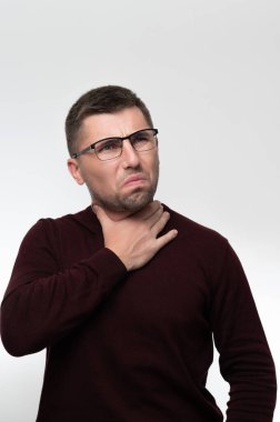 Handsome man in glasses over isolated background touching painful neck, sore throat from flu, cold and infection, man with light beard.