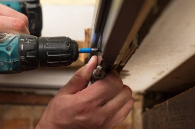 Installing a stainless hinge on an interior door, screwing a screw in a detailed plan, installing an interior door.