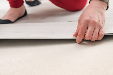 Zemin kurulumu, yeni bir kuvars stili vinil zemin döşeme onarımı, döşeme onarımı, bir kadın döşeme montajı.