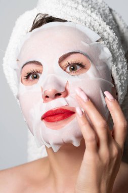 Fabric refreshing face mask, skin care, portrait of a woman with a mask on her face.