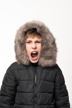 Beyaz arka planda kapüşonlu bir çocuk duygularıyla bir çocuğun saldırganlığını gösterdi. Öfkeden ağlayan bir çocuğun..