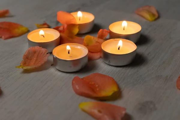 Rose petals and scented candle set, romantic evening, five candles and flower petals.